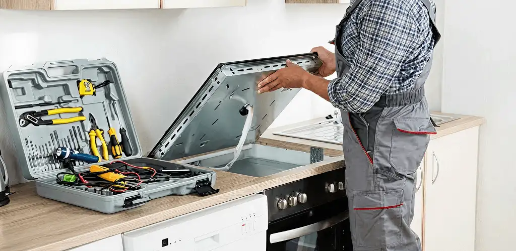 Handyman repairing a cooktop and checking wiring connections in Sacramento, CA