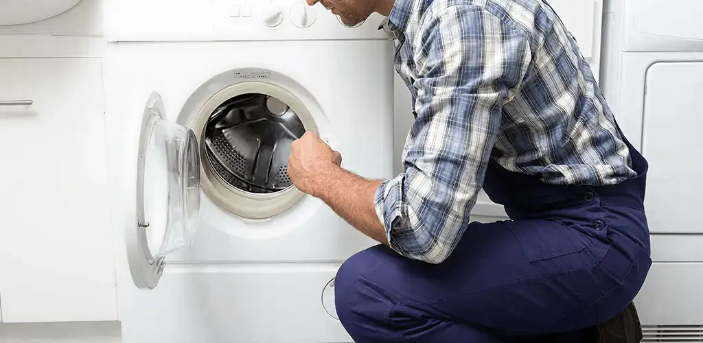 Handyman inspecting a dryer drum and internal parts for repair in Sacramento, CA