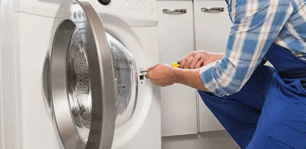 Handyman repairing a clothes dryer and checking electrical connections in Sacramento, CA
