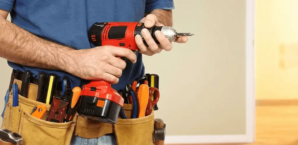 Handyman holding a power drill for home repairs and installations in Sacramento, CA