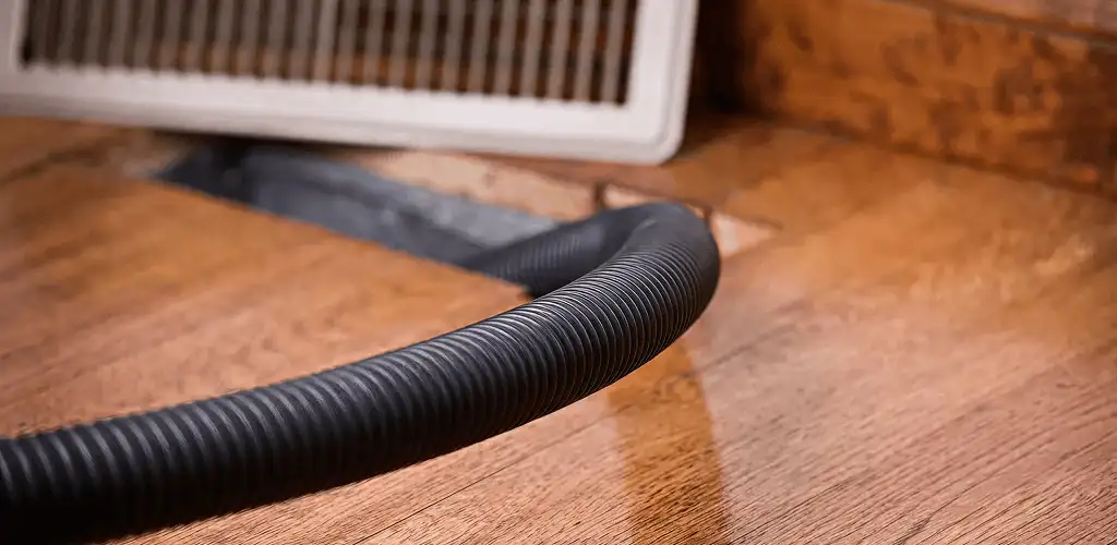 Air duct cleaning hose inserted into a floor vent for ductwork cleaning in Sacramento, CA