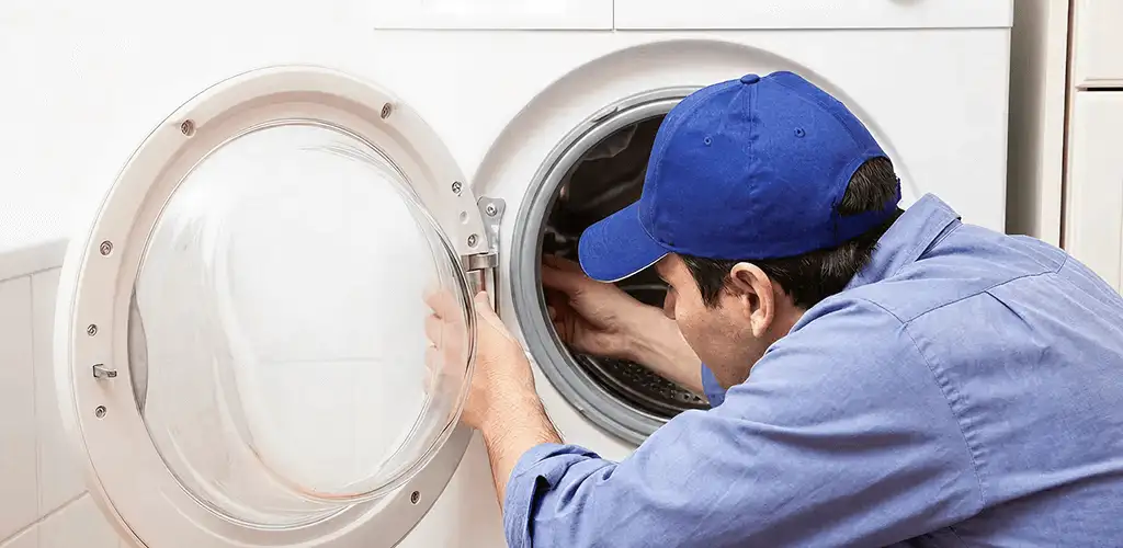 Washing machine repair handyman inspecting a front-load washer drum in Sacramento, CA